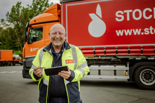 LKW-Fahrer mit Tablet Mann, der vor einem LKW steht und ein Tablet hält