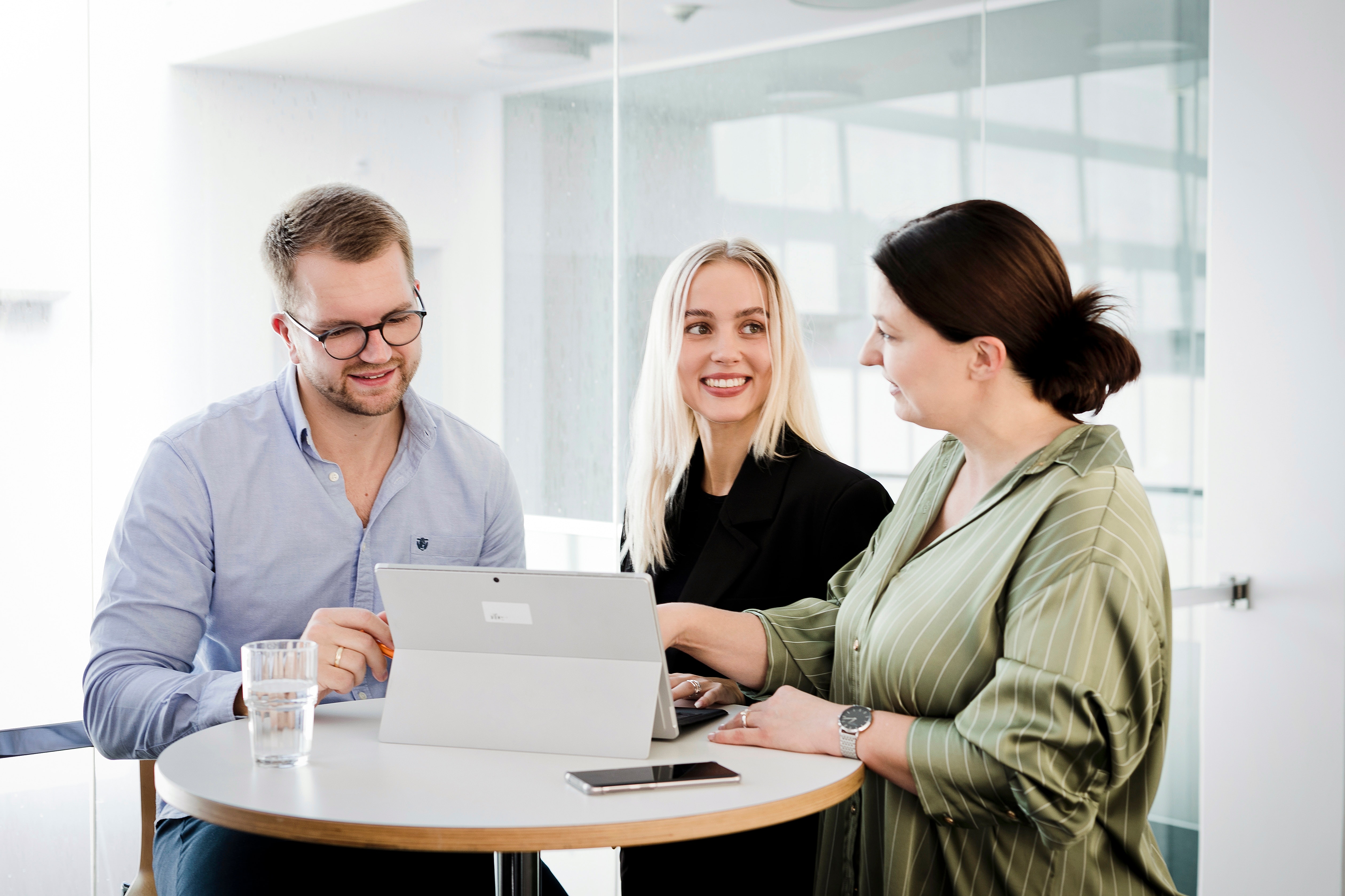 Besprechung Drei Mitarbeitende in einer Besprechung
