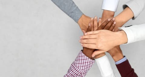 Ein Team Diverses Team legt die Hände übereinander