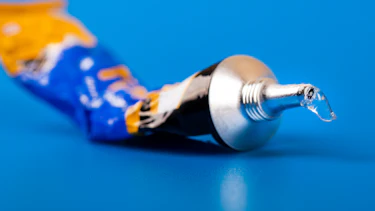 Super glue tube on blue background Super glue tube on blue background