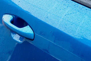 Photo of blue car door handle and lock Photo of blue car door handle and lock