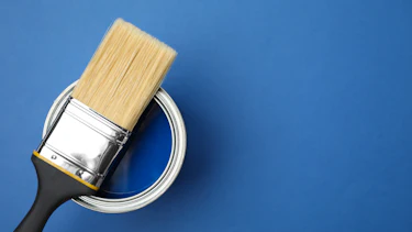 Open can and paint brush on blue background Open can and paint brush on blue background