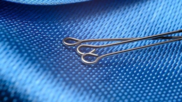 Three sewing pins on blue blackground Three sewing pins on blue blackground