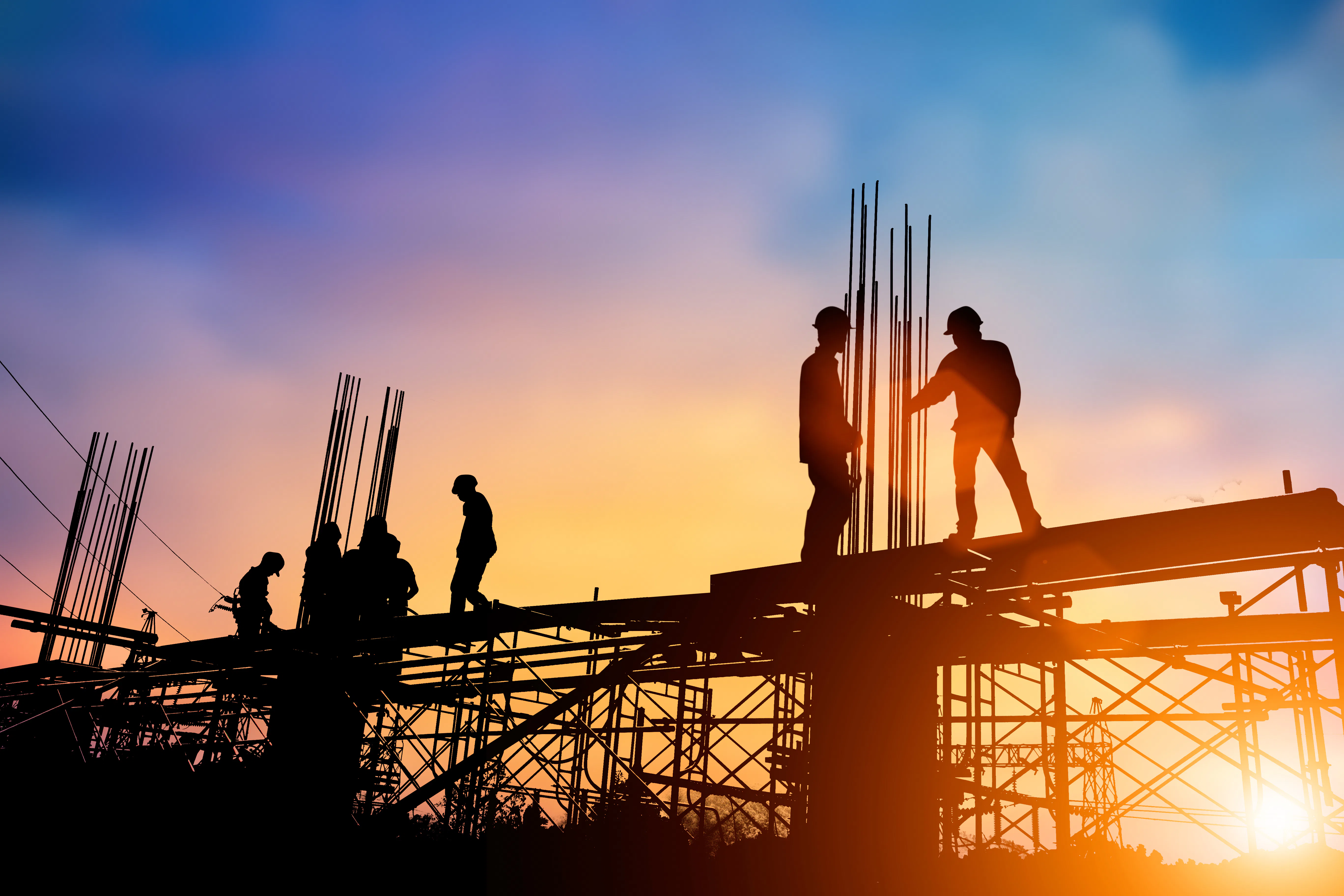 Silhouettes of several engineers standing in front of construction Silhouettes of several engineers standing in front of construction