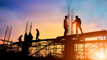 Silhouettes of several engineers standing in front of construction Silhouettes of several engineers standing in front of construction