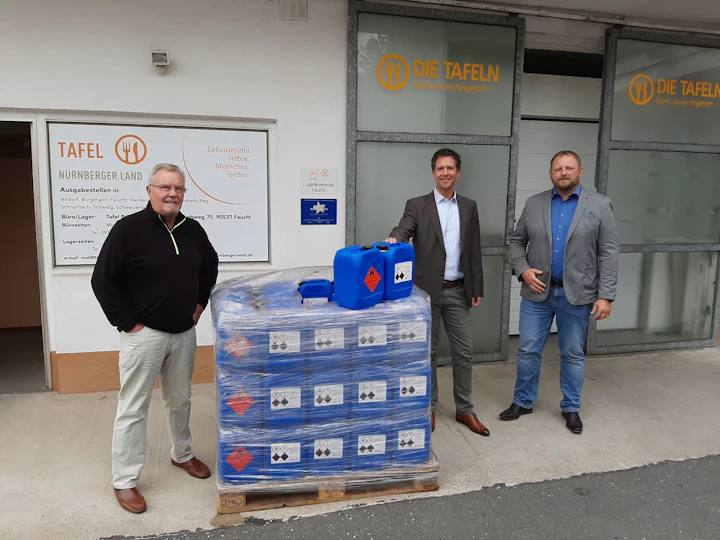 Employees of TAFEL and STAUB & CO. – SILBERMANN with a pallet of disinfectant in front of the Tafel Landesverband Bayern e. V. warehouse.