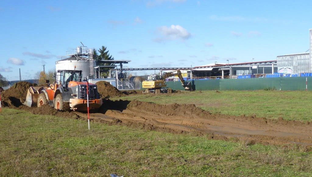 Initial work on the contstruction site A wheel loader removes the meadow to prepare the construction site. This is where the new underground tank farm for solvents was built.