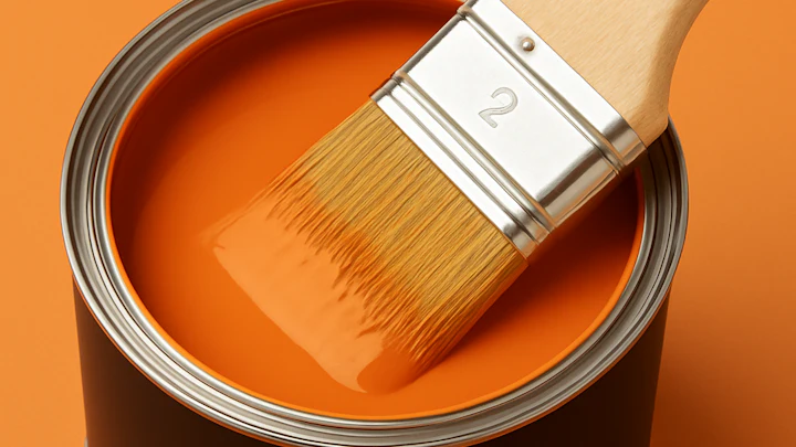Orange paint bucket with brush and orange paint