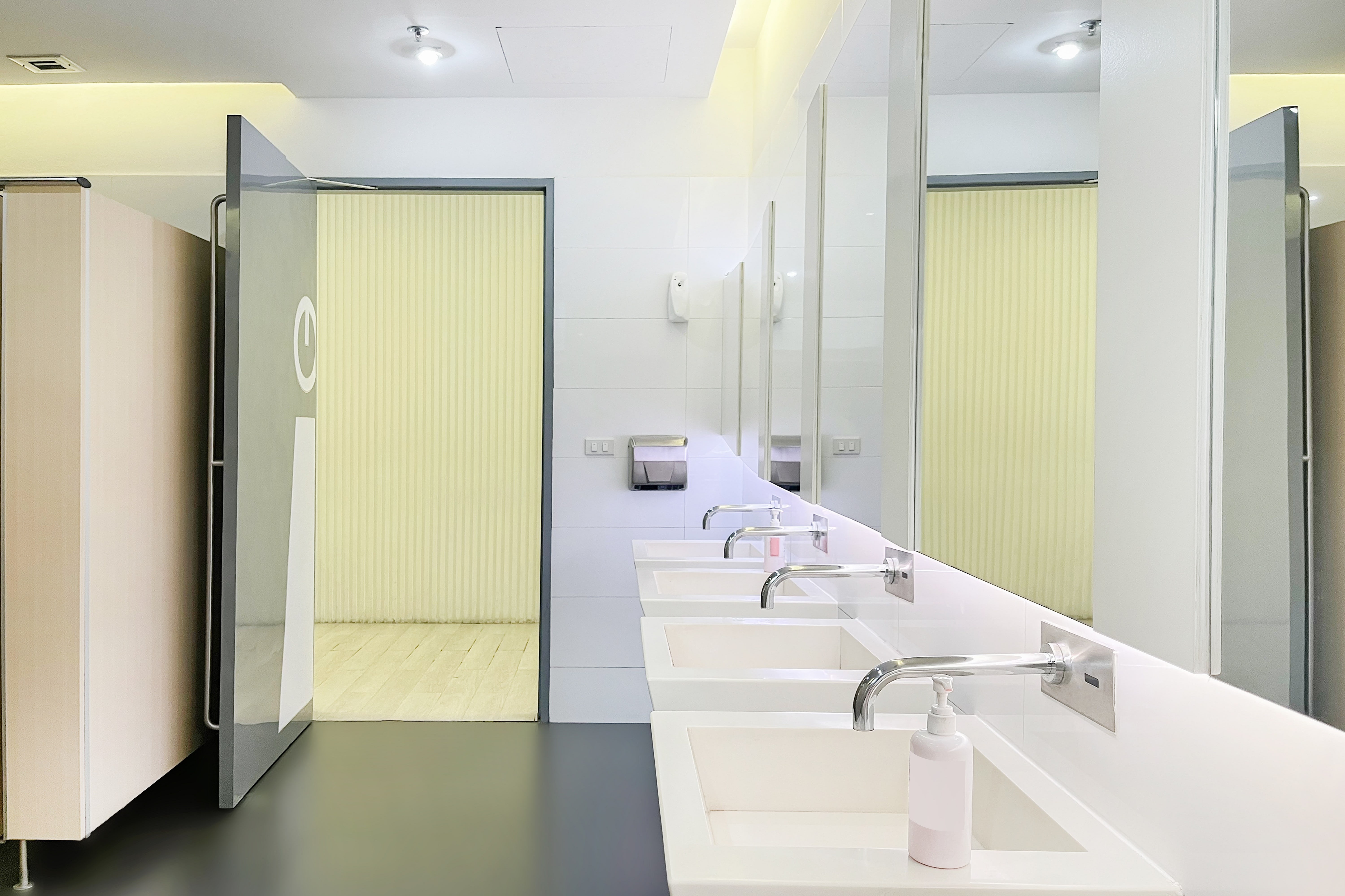 Washroom with cubicles with washbasin and soap dispenser in the front Washroom with cubicles with washbasin and soap dispenser in the front