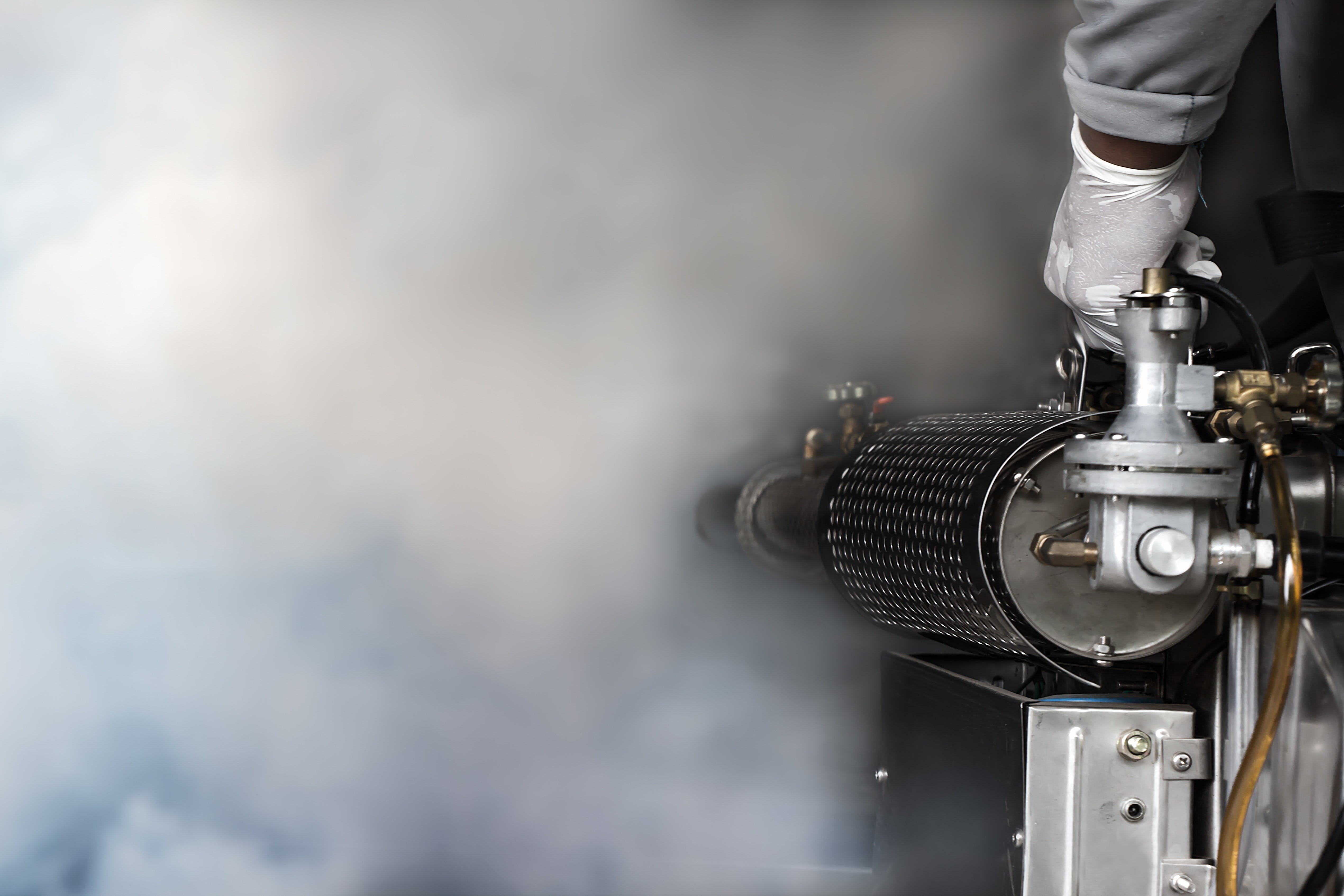 A specialist in a protective suit uses a machine for disinfection A specialist in a protective suit uses a machine for disinfection