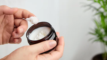 Finger holt Creme aus Tiegel Finger holt Creme aus Tiegel
