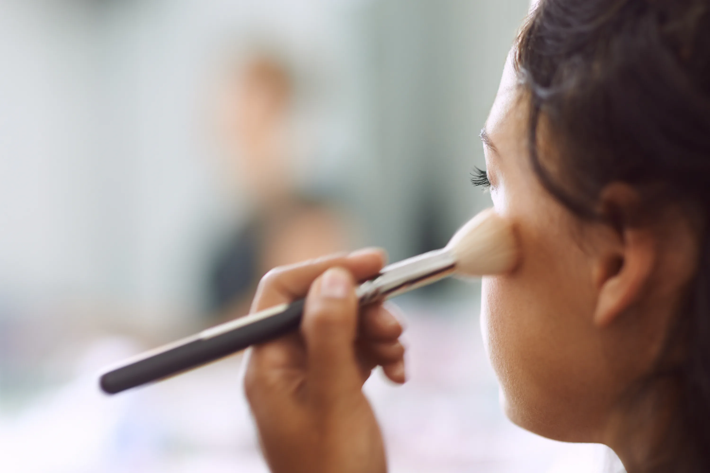Dekorative Kosmetik Eine Frau benutzt einen Make-Up Pinsel
