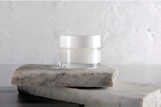 Hautpflegeverpackung Tiegel auf Steinplatte Hautpflegeverpackung Tiegel auf Steinplatte