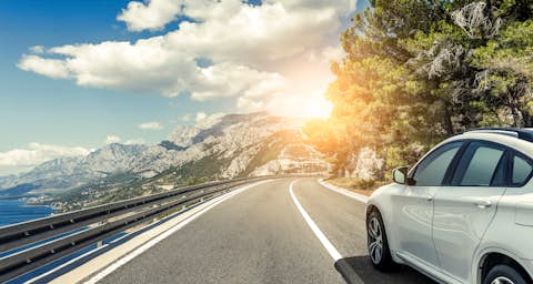 Weißes Auto auf der Straße gegenüber der Sonne Weißes Auto auf der Straße gegenüber der Sonne