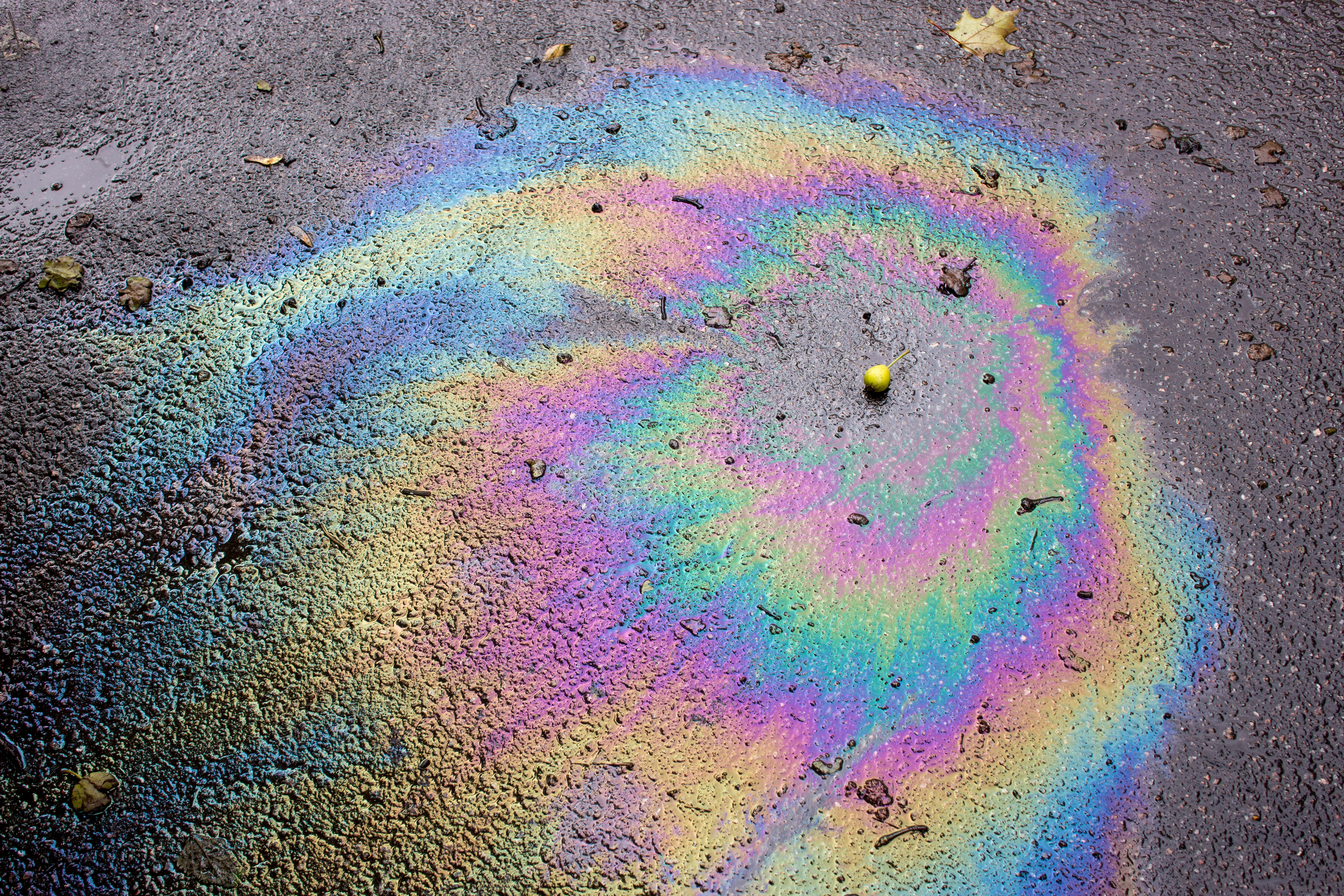 Coloured petrol and oil stains on the asphalt Coloured petrol and oil stains on the asphalt
