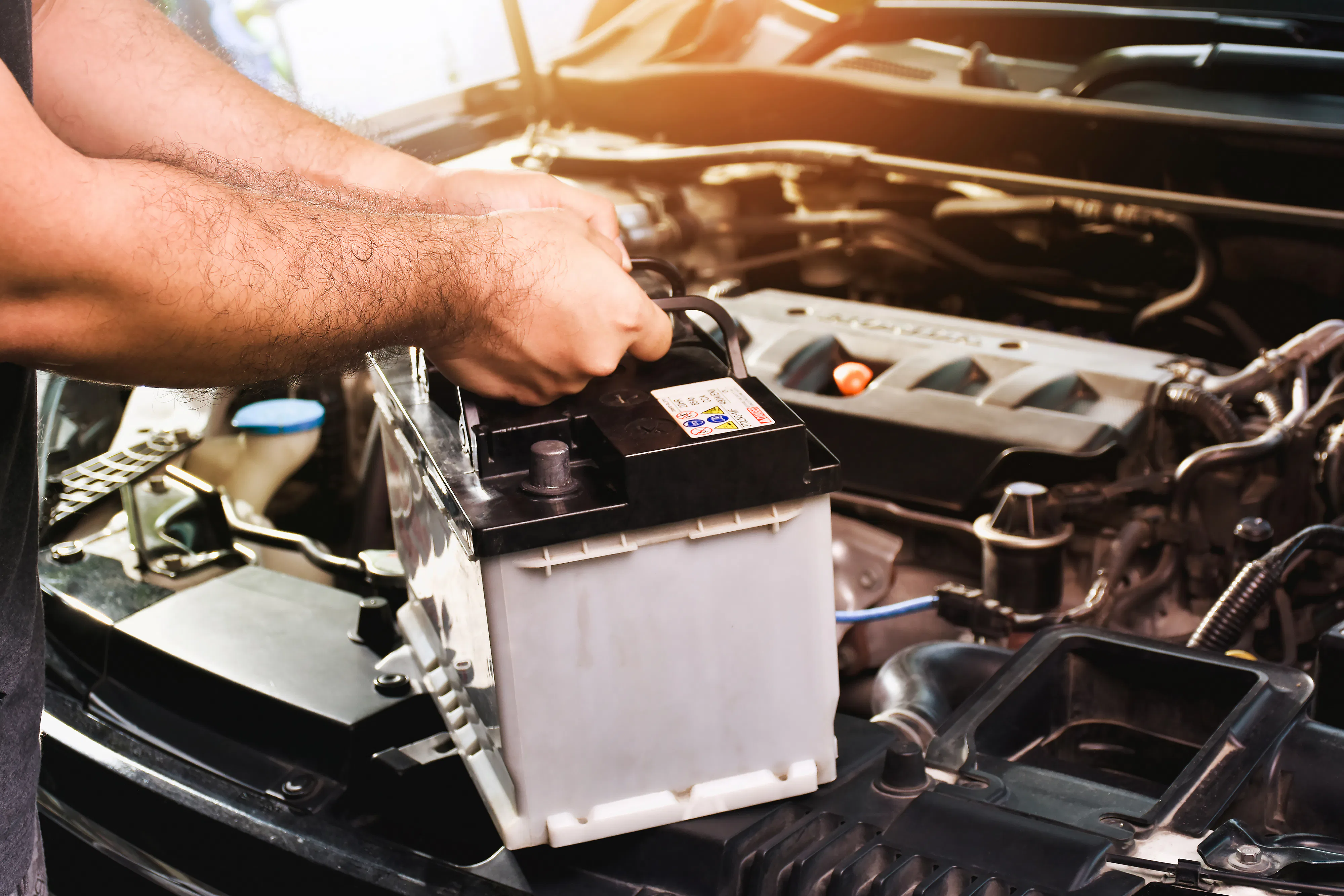 Person installing a vehicle battery Person installing a vehicle battery