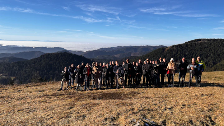 Teamfoto an einem Aussichtspunkt, im Hintergrund sind die Berge des Schwarzwalds zu sehen