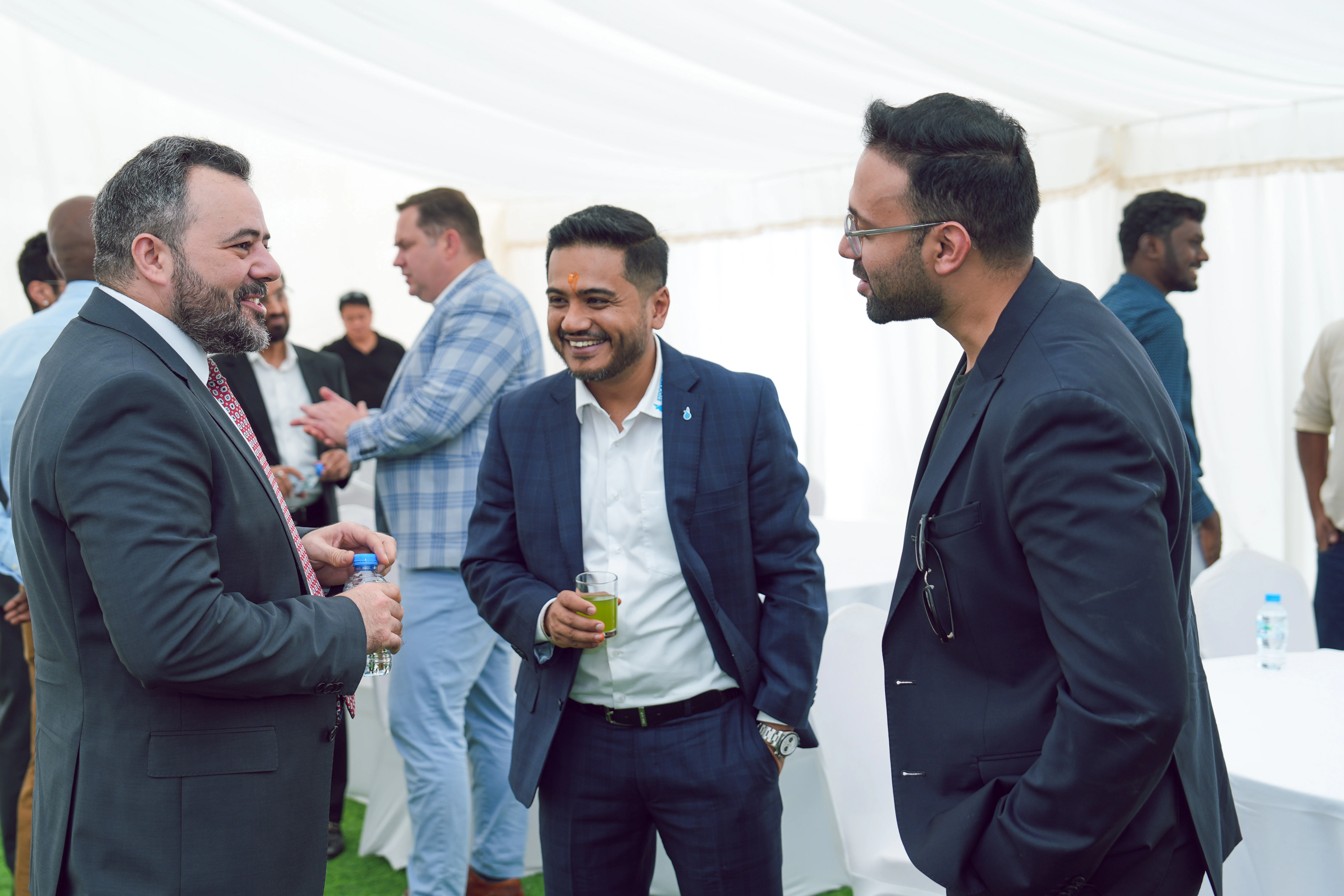 Das Dubai Team im Gespräch mit Gästen Drei Männer in einem Zelt unterhalten sich miteinander