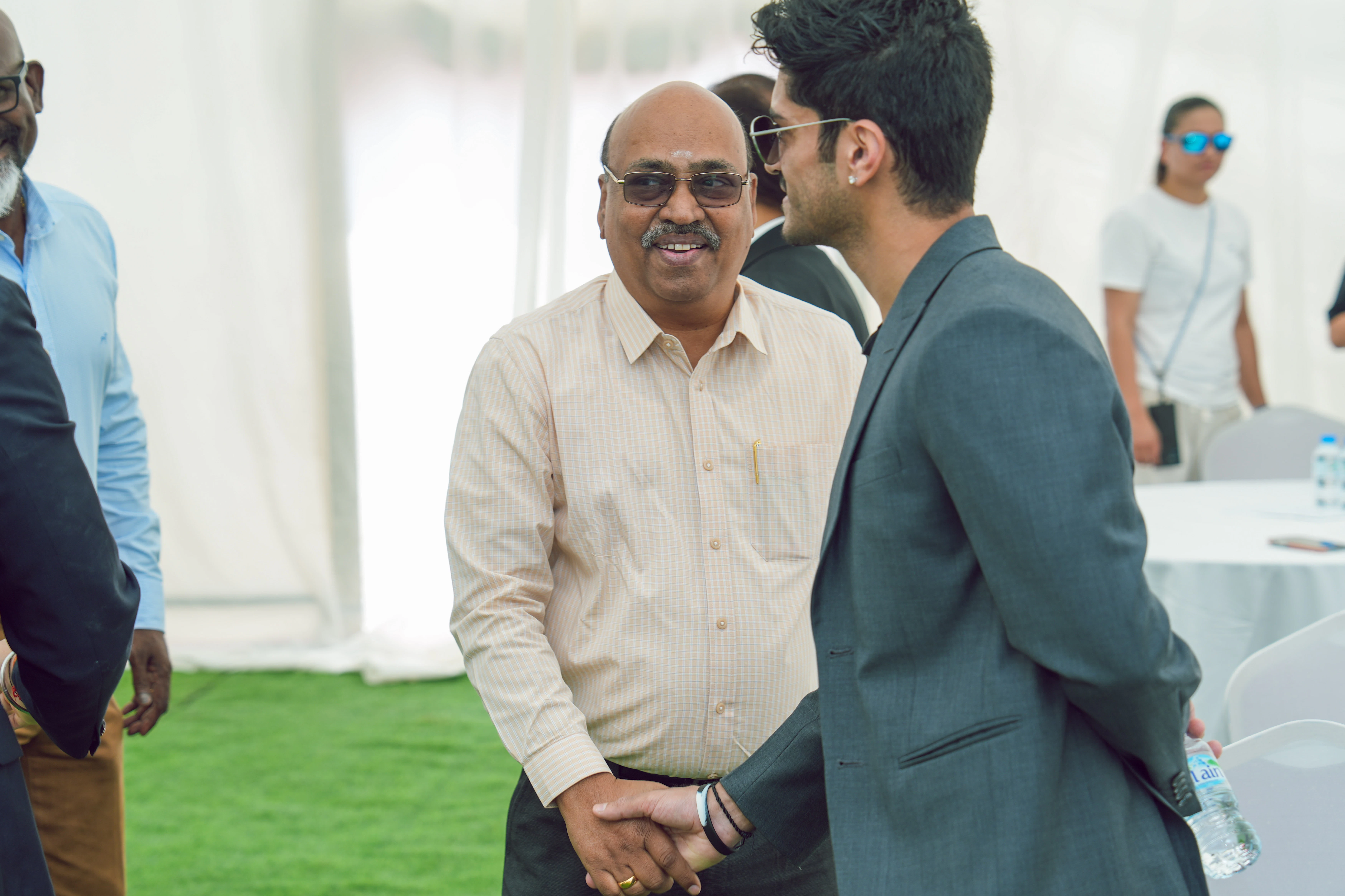 Gäste unterhalten sich währen des Spatenstich-Events Männer stehen im Kreis und unterhalten sich miteinander