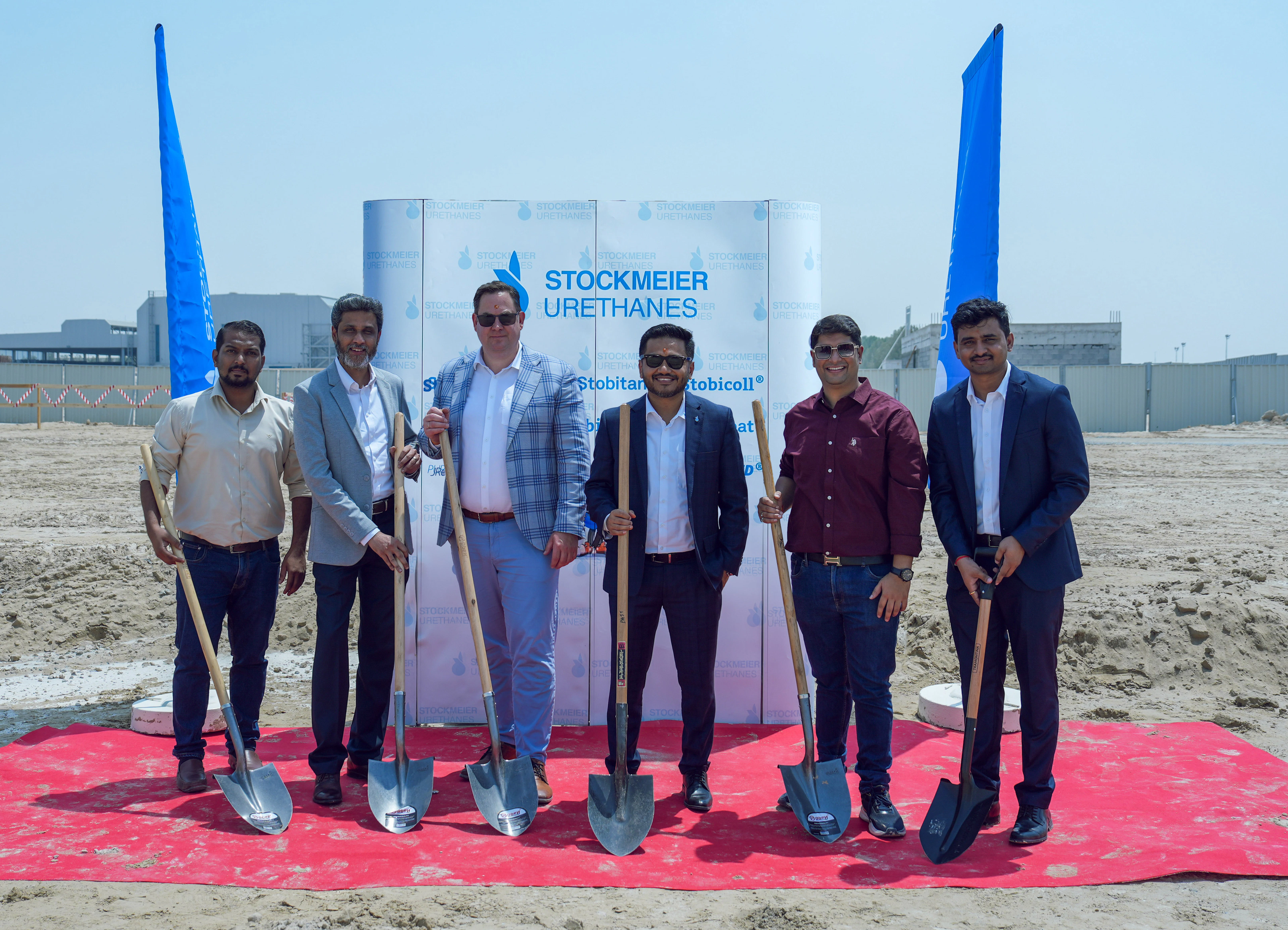 Teilnehmende beim Spatenstich in Dubai Gäste stehen auf einem roten Teppich mit Schaufeln in ihren Händen