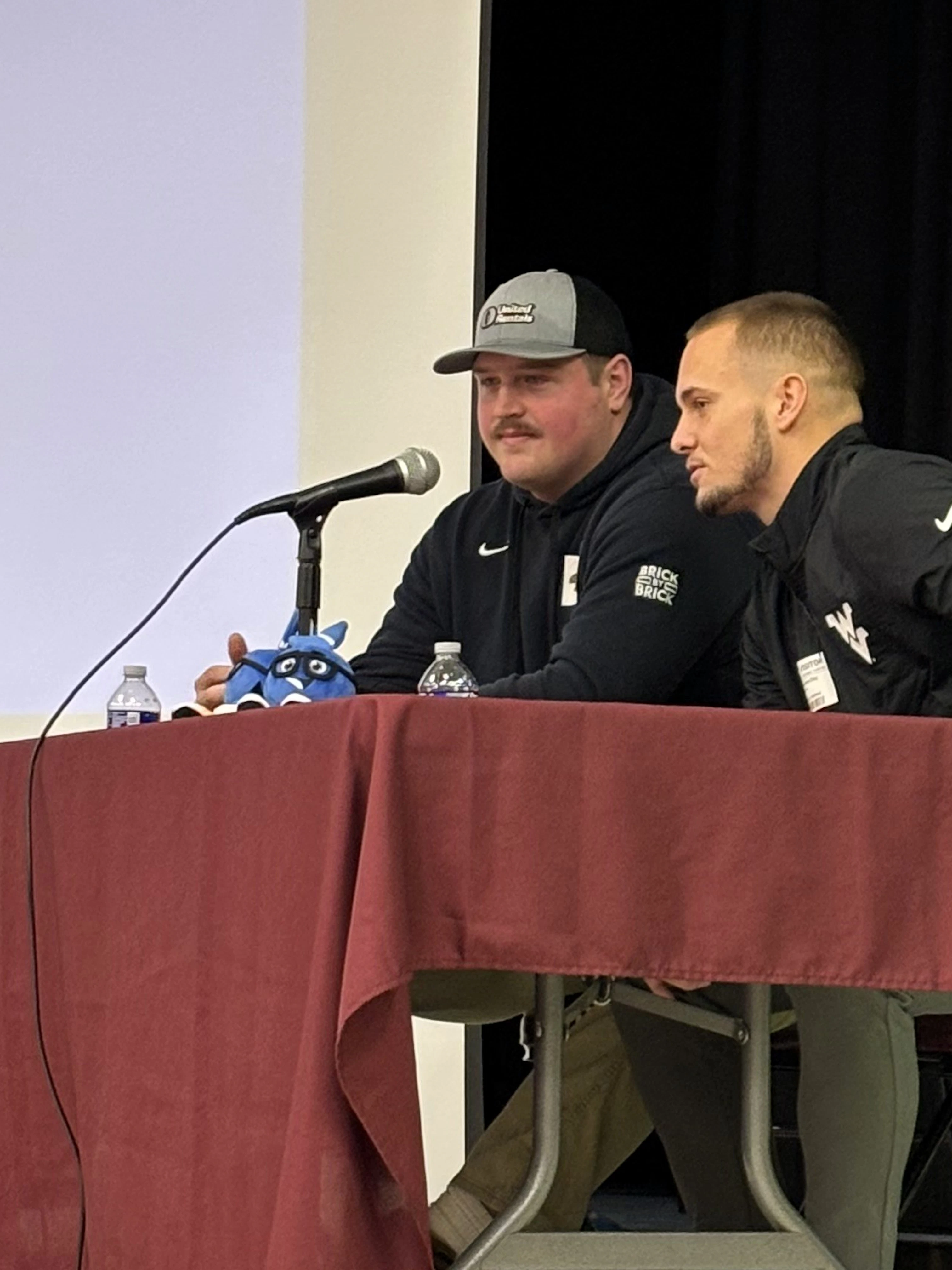 Nick Malone and Preston Fox on stage at South Middle School in Morgantown, West Virginia Nick Malone and Preston Fox on stage talking to students with West Virginia logo on the screen behind them