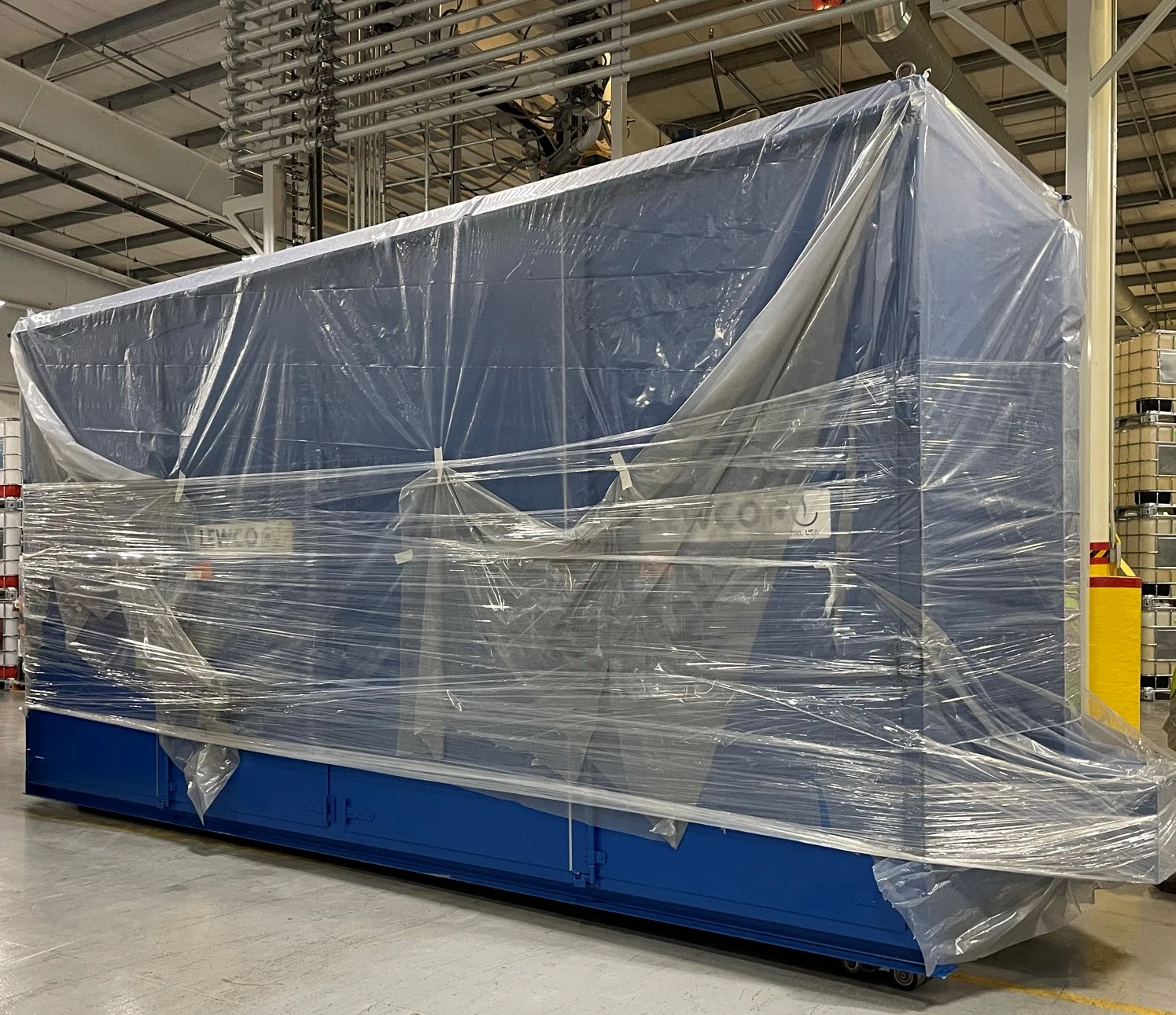 Neues Equipment zieht bei STOCKMEIER Urethanes USA ein Blauer Ofen mit Folie umwickelt in einer Halle