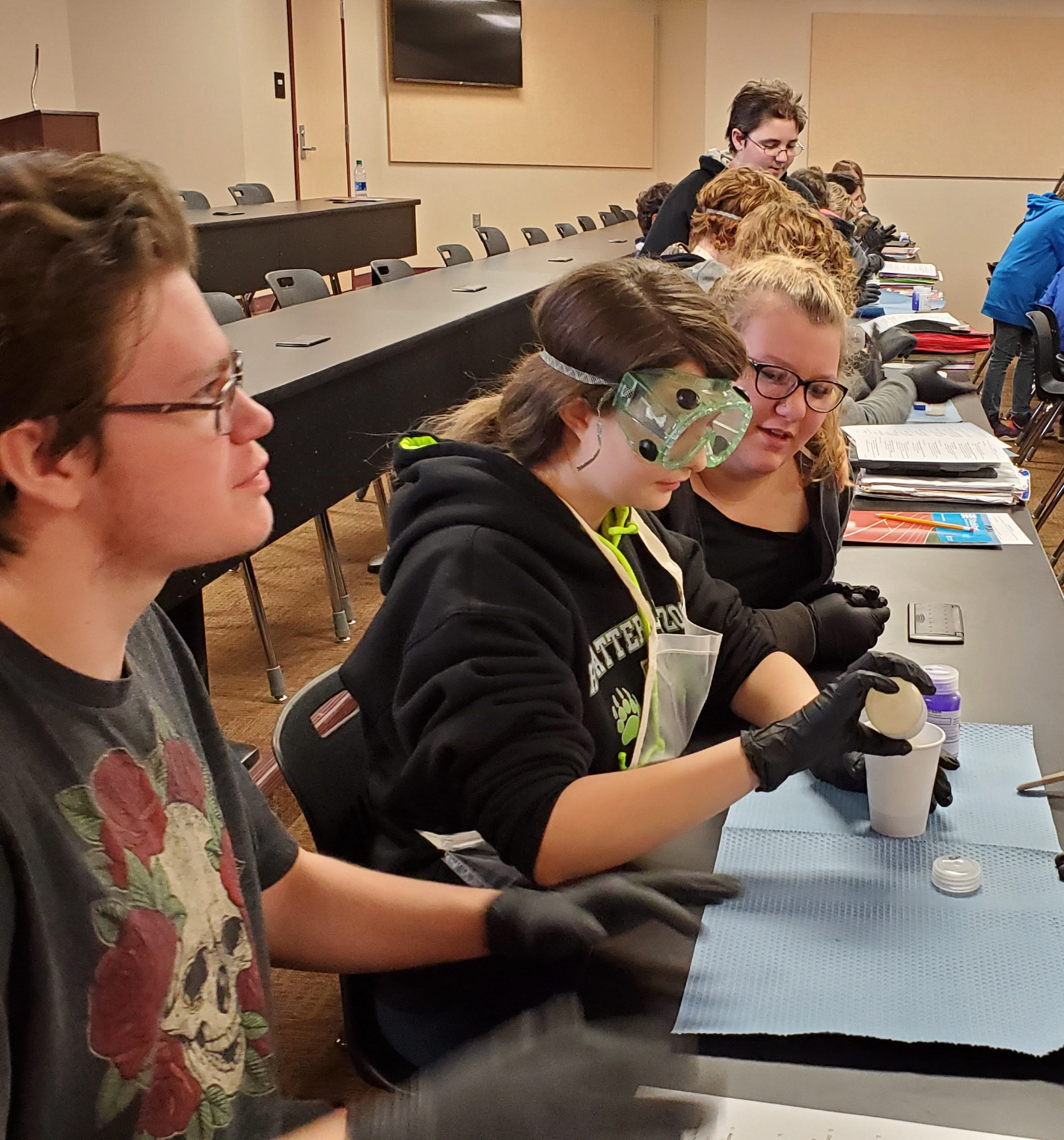 STOCKMEIER Urethanes kooperiert mit WVMA 9 Schülerinnen mit Schutzbrillen sitzen an einem Tisch und füllen eine Flüssigkeit in einen Becher