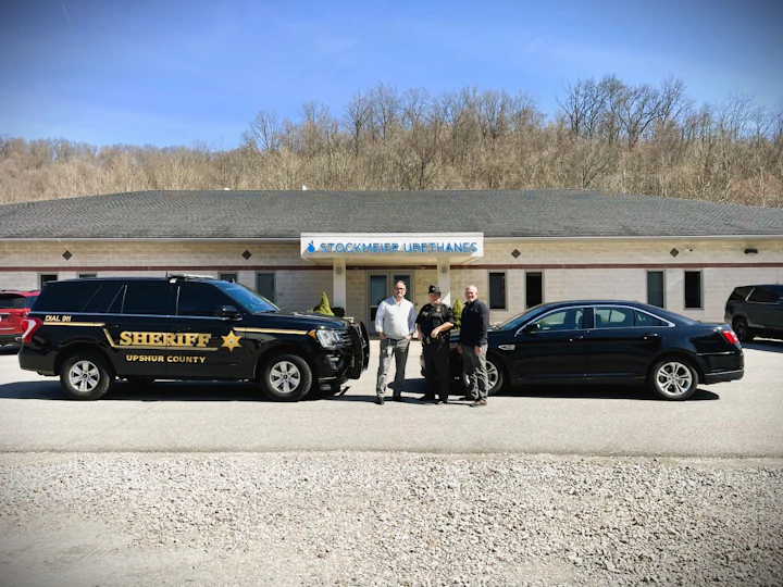 Sheriff und Mitarbeiter von STOCKMEIER Urethanes stehen vor dem neuen Fahrzeug des örtlichen Sheriff Departments